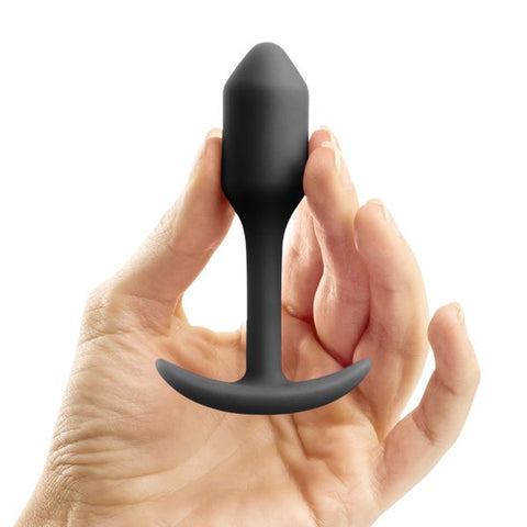 tiny tapered snug plug 1 silicone butt plug held up by a hand
