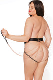 plus size model is facing away from the camera and is wearing a panty with a thick black elastic waist band and elastic straps that frame the butt. The panty back is open except for 3 rose gold straps on each cheek. the chains are connected to an o-ring on the waistband a matching rose gold leash is hooked to the o-ring.