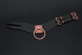 a flatlay of the black and rose gold vegan bdsm collar shows two buckles with rose gold hardware.