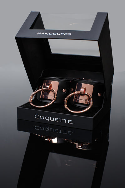 shows off the gorgeous window gift box housing the black and rose gold submissive handcuffs