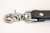 closeup of metal snaphook end of black garment leather bdsm training leash