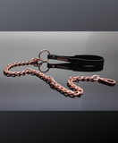 black vegan wrist loops affixed to a rose gold ring and chain leash.  