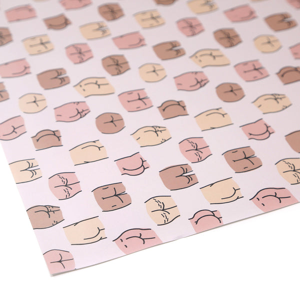 A close up of a corner of  wrapping paper with white background and butts outlines in different shapes, sizes, and colors. T