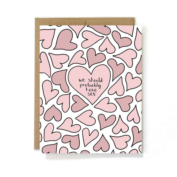A cute greeting card. Pink hearts surround a larger pink heart in the middle of the card. The text in the middle heart reads “we should probably have sex”  This card is made by Unblushing a Women-Owned small sex positive graphic designer.
